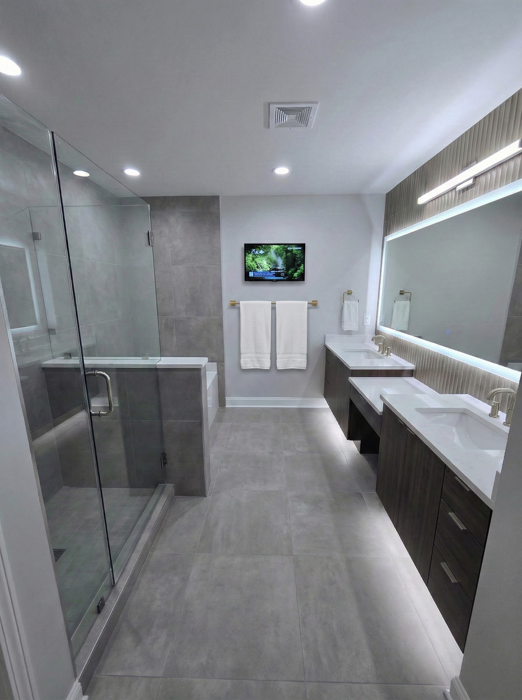 Bathroom after renovation with a vanity, mirror, and tiled shower