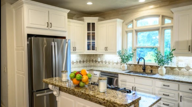 Refrigerator surround with refinished white cabinets and granite counters