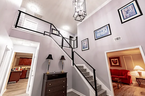 Remodeled stair landing with black metal railing and gray flooring