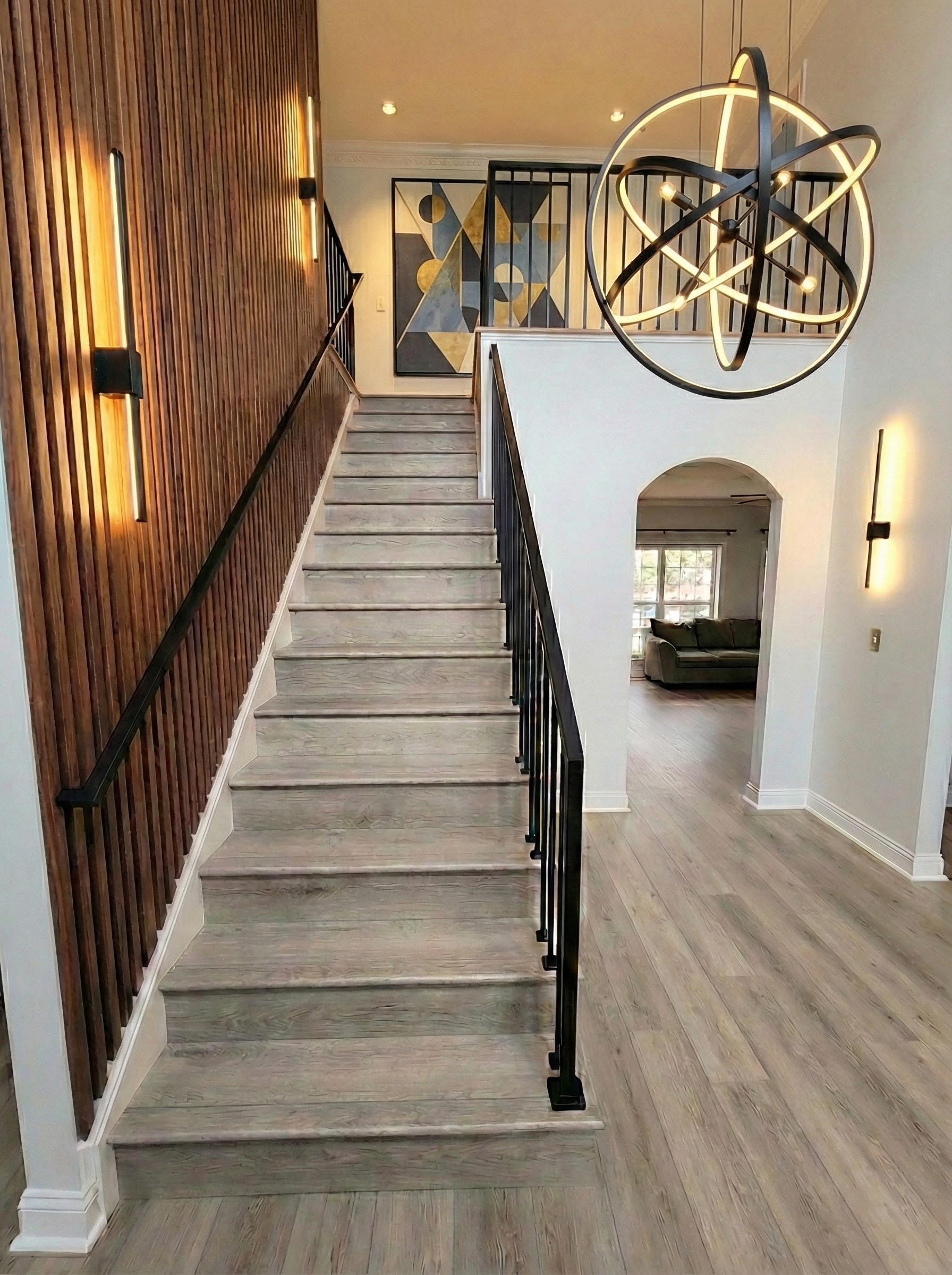 Staircase after renovation with wood treads and dark metal railings