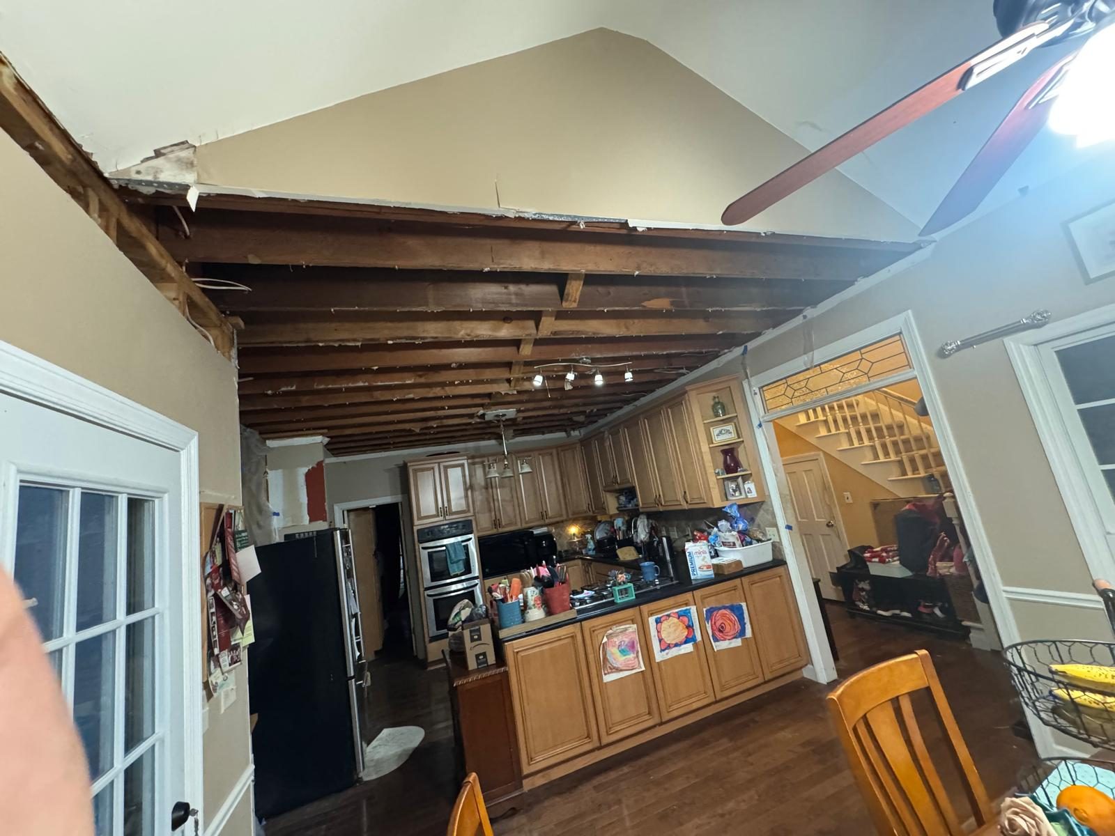 Original kitchen with oak cabinetry and heavy exposed timber ceiling before renovation