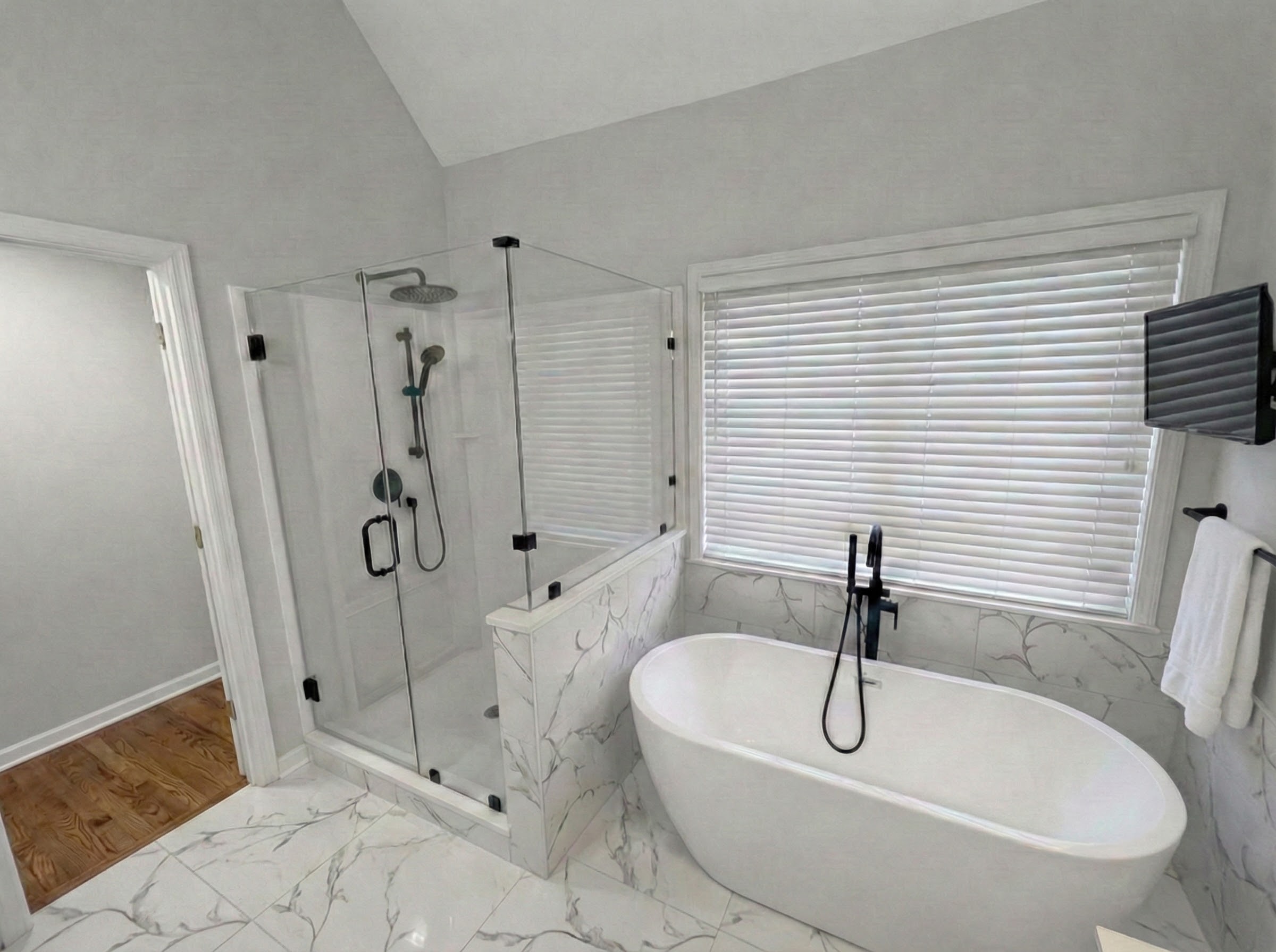 Bathroom after renovation with a glass shower, double vanity, and gray tile
